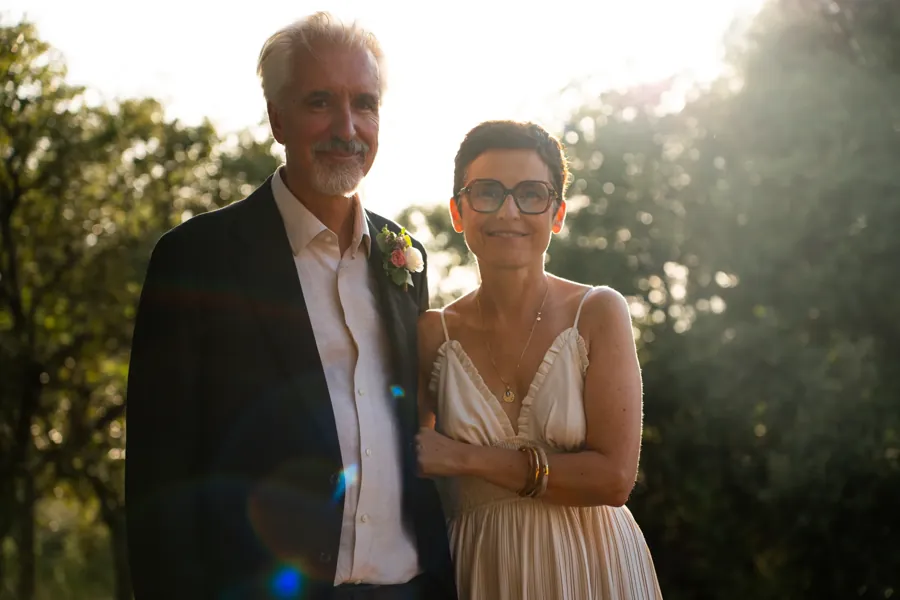 Couple de mariés souriants à contre-jour, lumière du soir