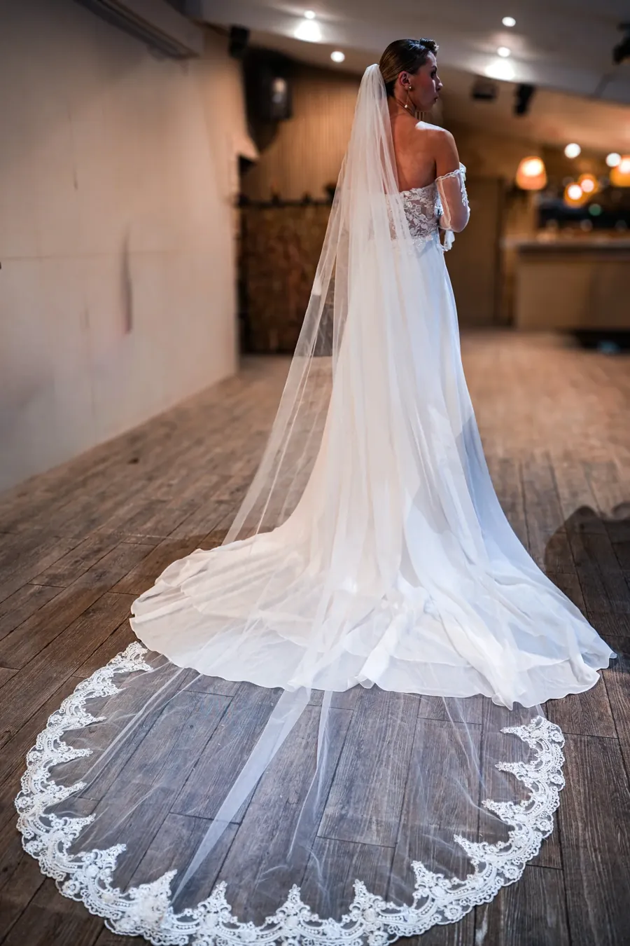 Mariée de dos, longue traîne et voile en dentelle